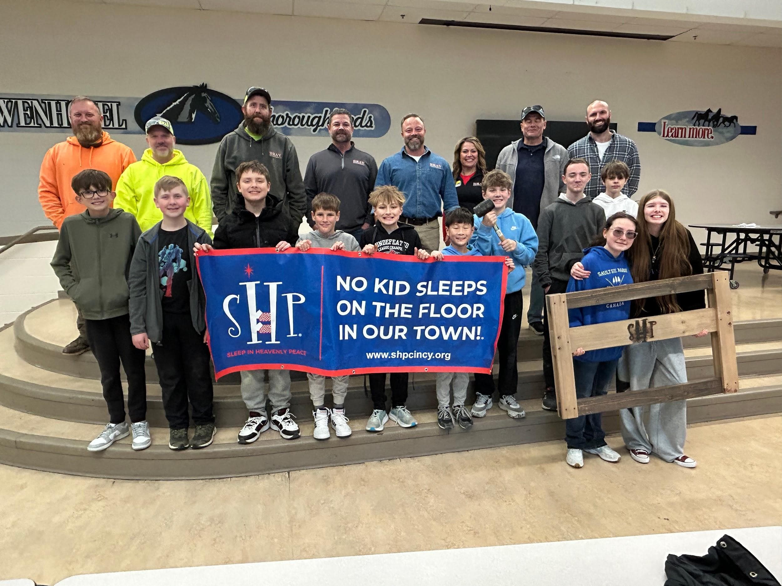 Twenhofel Middle School students and Bray Construction volunteers celebrate their completed bed build with nonprofit partner Sleep in Heavenly Peace